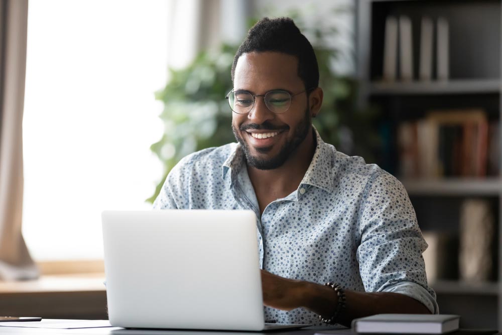 Smiling man in glasses sit at desk in office