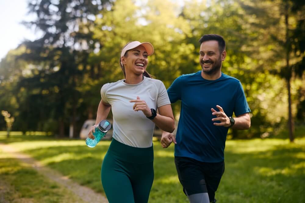 Happy athletic couple having fun while running