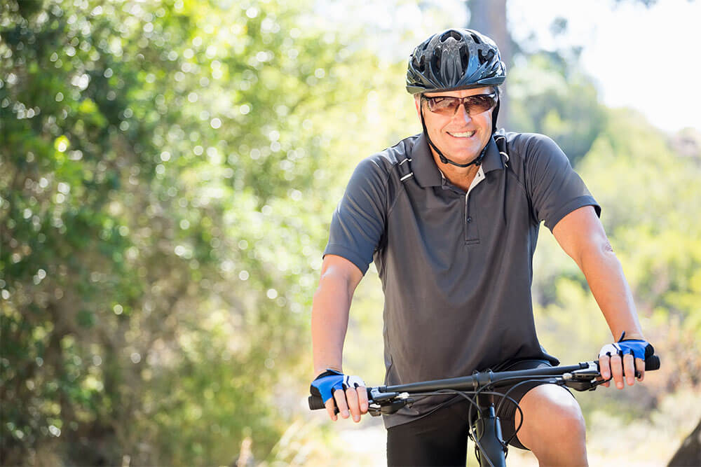 Man smiling and posing with his bike