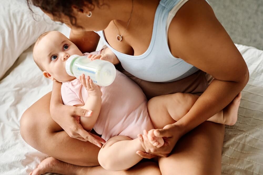 Mother giving milk to her baby