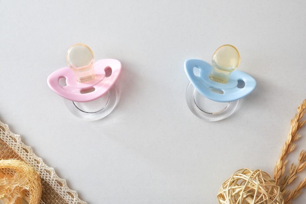 two blue and pink pacifiers