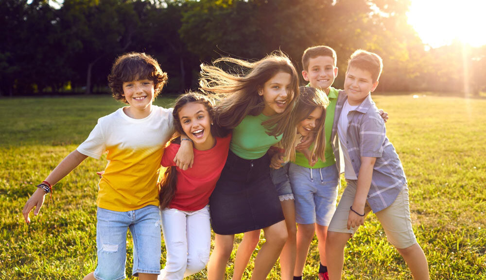 Group of happy cheerful active little children enjoying summer break