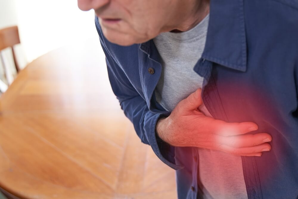 Senior man pressing hand on chest with pain