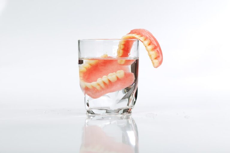 A set of dentures in a glass of water