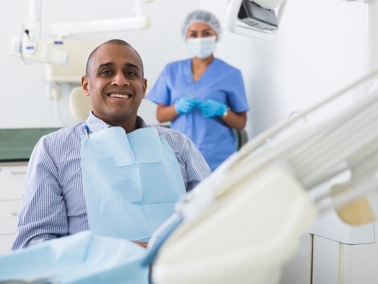 Smiling Latin American Sitting In Dental Chair