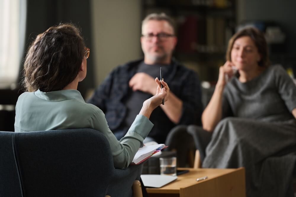 Couple having therapy session with female therapist