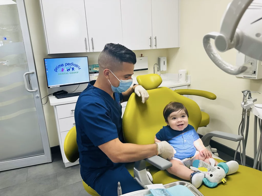 Office tour photos showing dental professional assisting toddler boy thats sitting in dental chair