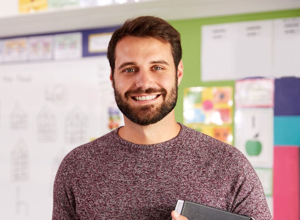 Male elementary school teacher smiling