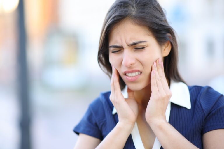 Stressed woman suffering tmj disorder complaining in the street