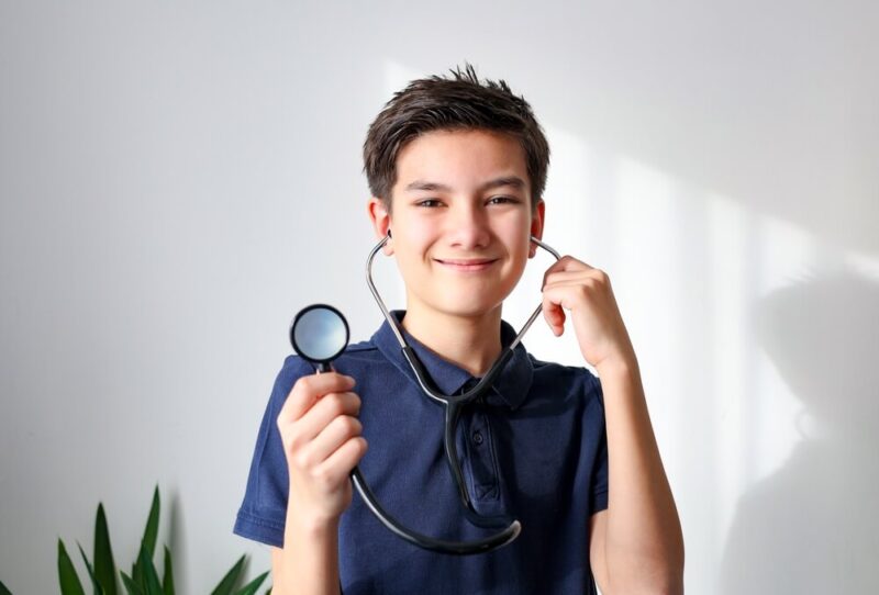 Adorable school boy play doctor