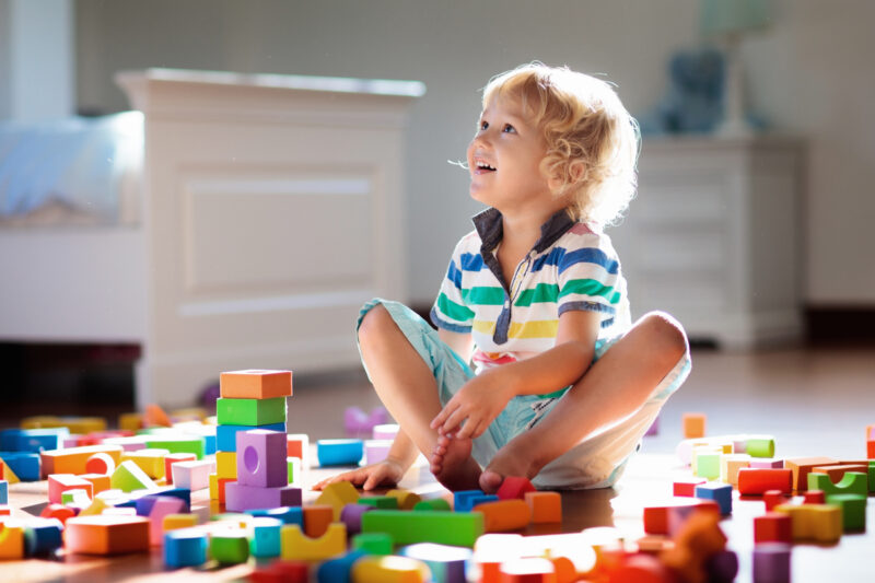 Child playing with colorful toy blocks