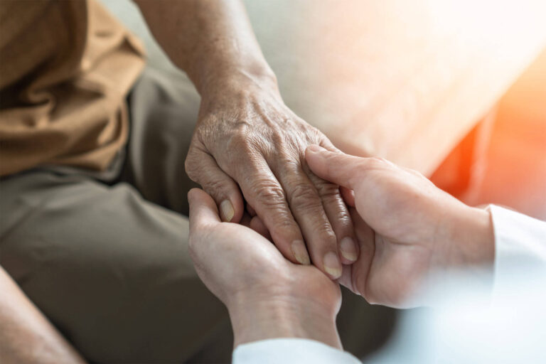 Doctor holding hand of elderly senior patient