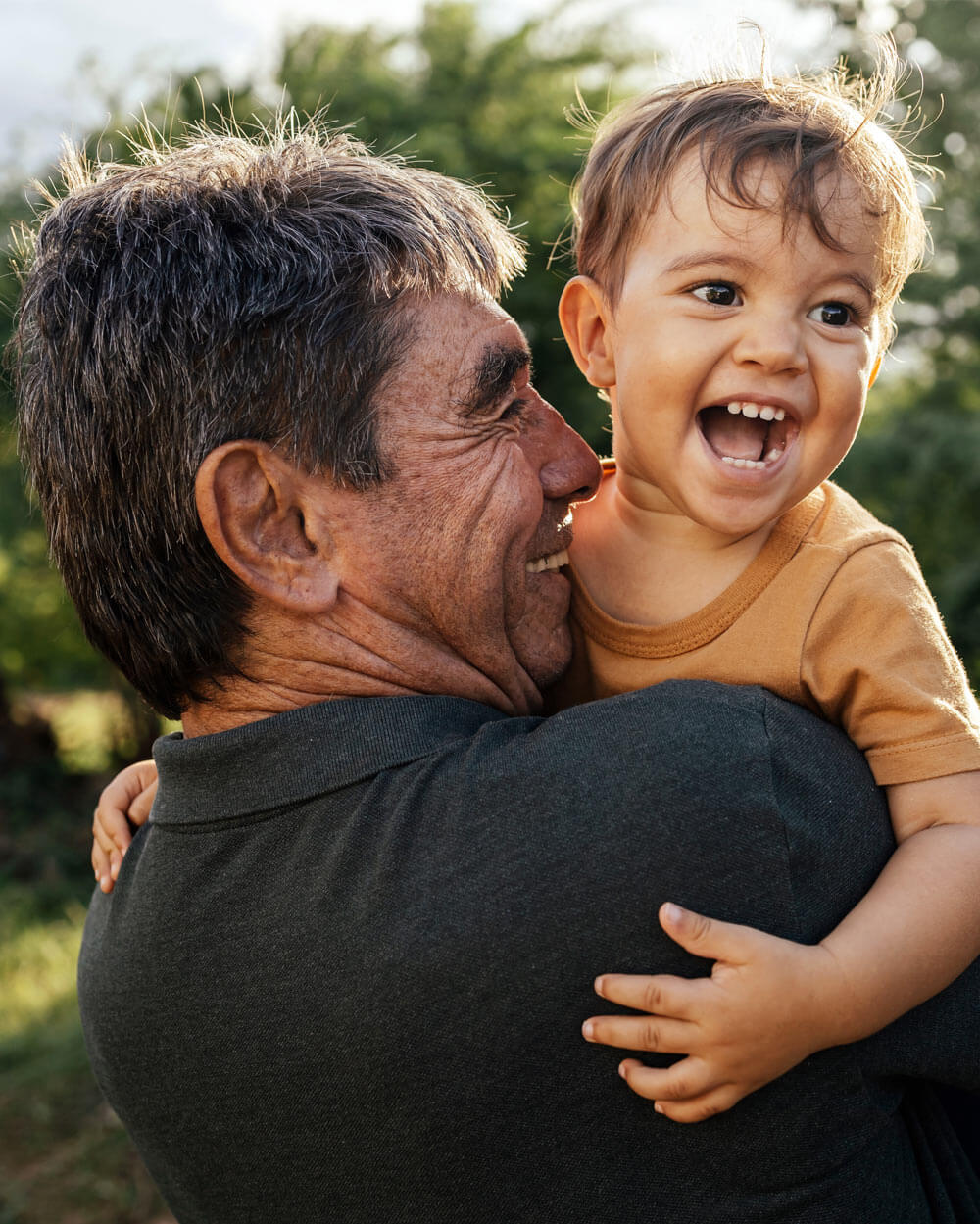 Playful grandfather spending time with his grandson in park