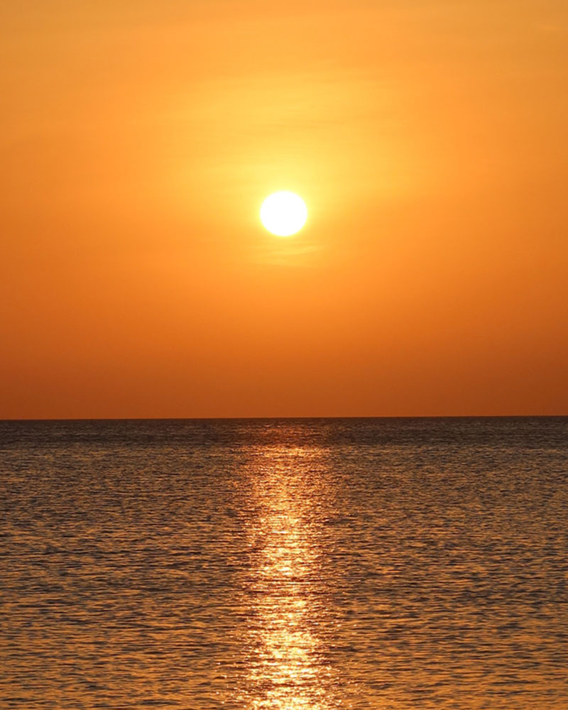 Golden sunrise over tranquil waters.