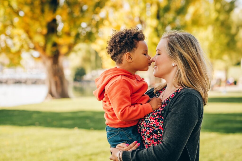 Happy young mother holding sweet toddler boy