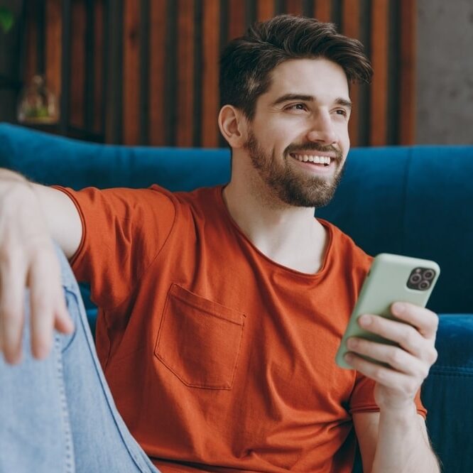 Young man wears red t-shirt hold use mobile