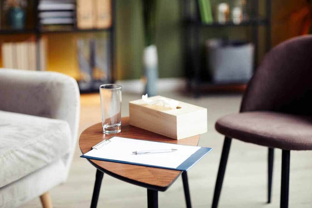 Clipboard with blank sheet, glass of water and napkin