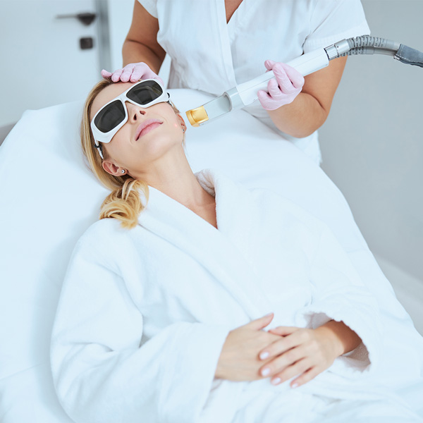 Calm blonde woman lying on the couch during the beauty procedure