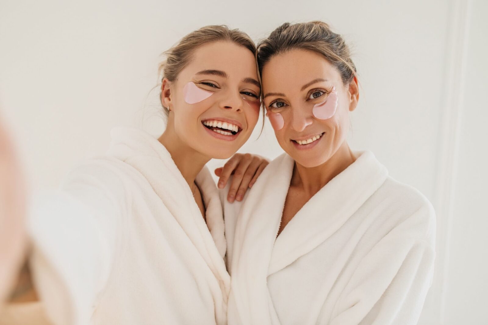 Happy mother with daughter wearing hydrogel patches smiling