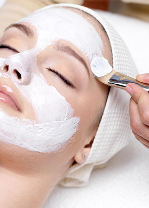 Beautiful woman with facial mask at beauty salon