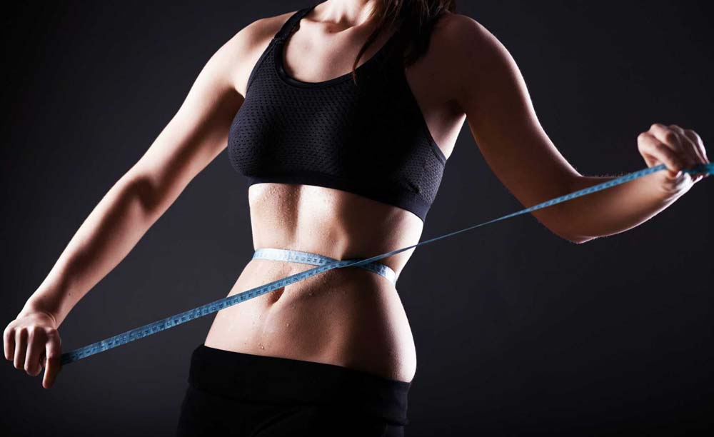 Woman measuring her waist