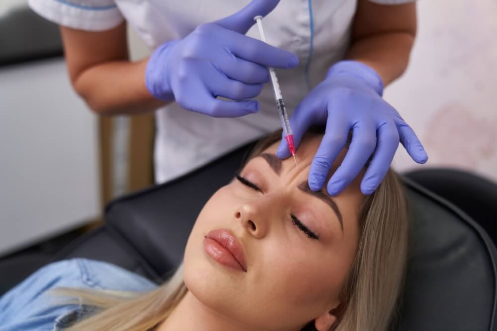 Woman having face-lifting procedure in beauty salon