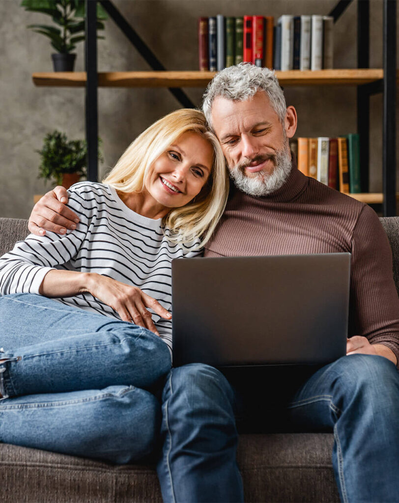 Senior couple using laptop and smiling