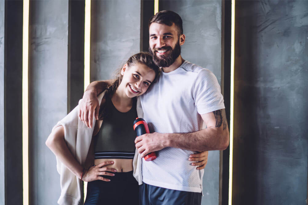 Cuddling sporty couple in workout clothes